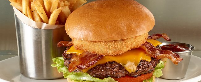 The Original Legendary Burger features a juicy 1/2-lb Certified Angus Beef burger topped with smoked bacon, cheddar cheese, golden fried onion ring, crisp lettuce and vine ripened tomato.
